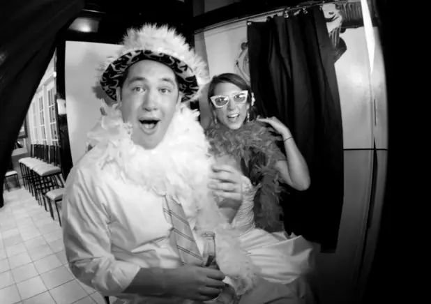 wedding guests in photo booth with silly hats and funny faces